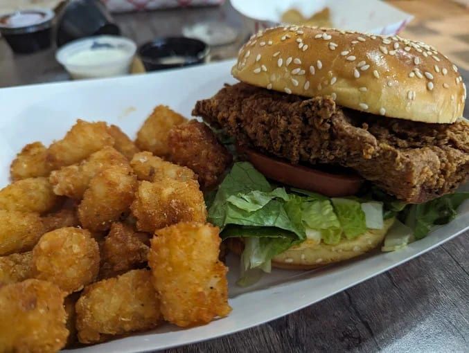 A fried chicken sandwich with tater tots